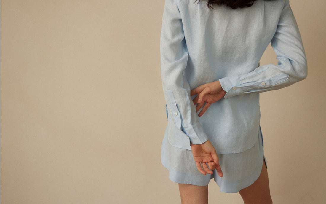Woman styling a modern linen shirt and shorts set by Whitney Linen for resort dressing