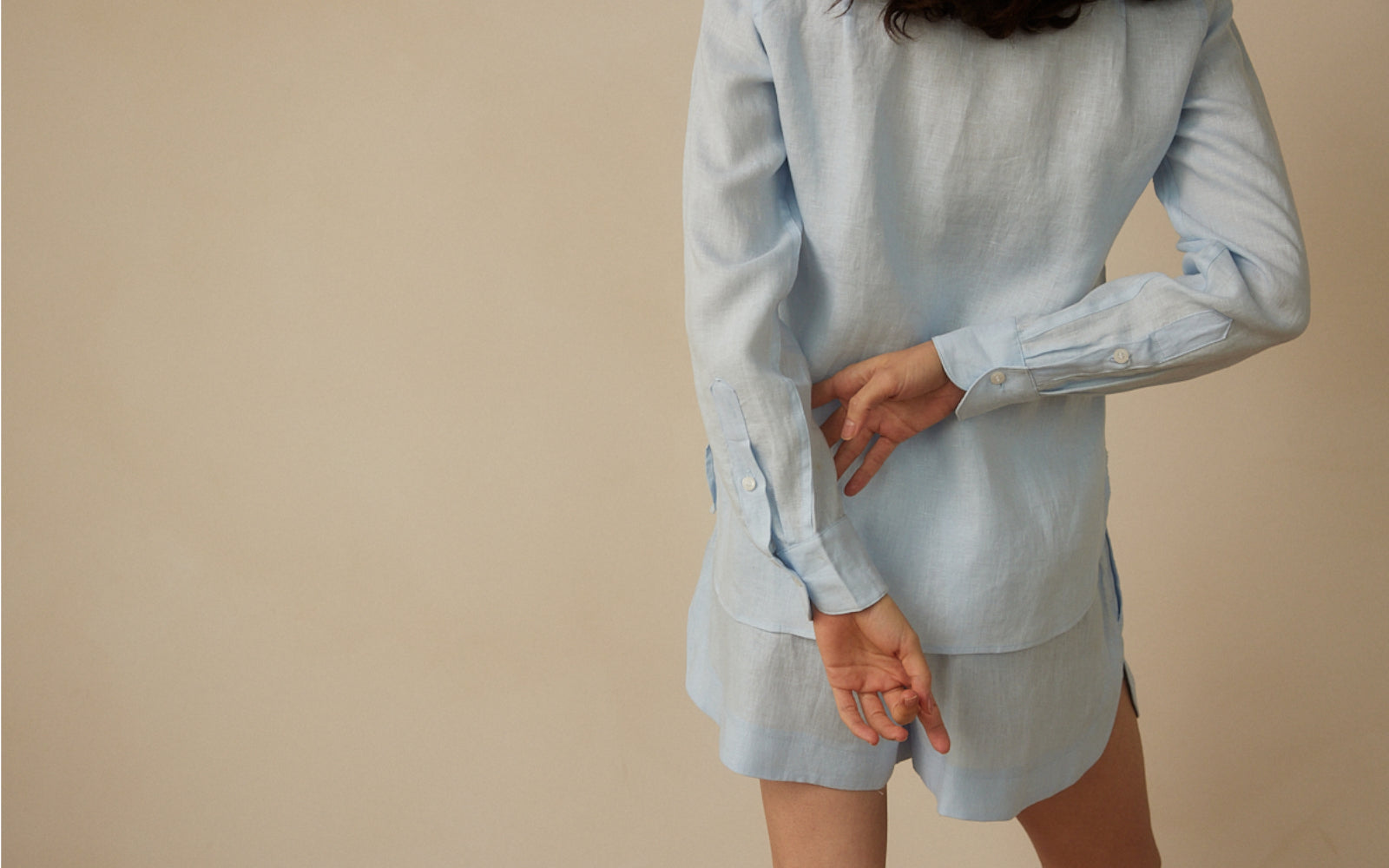 Woman styling a modern linen shirt and shorts set by Whitney Linen for resort dressing
